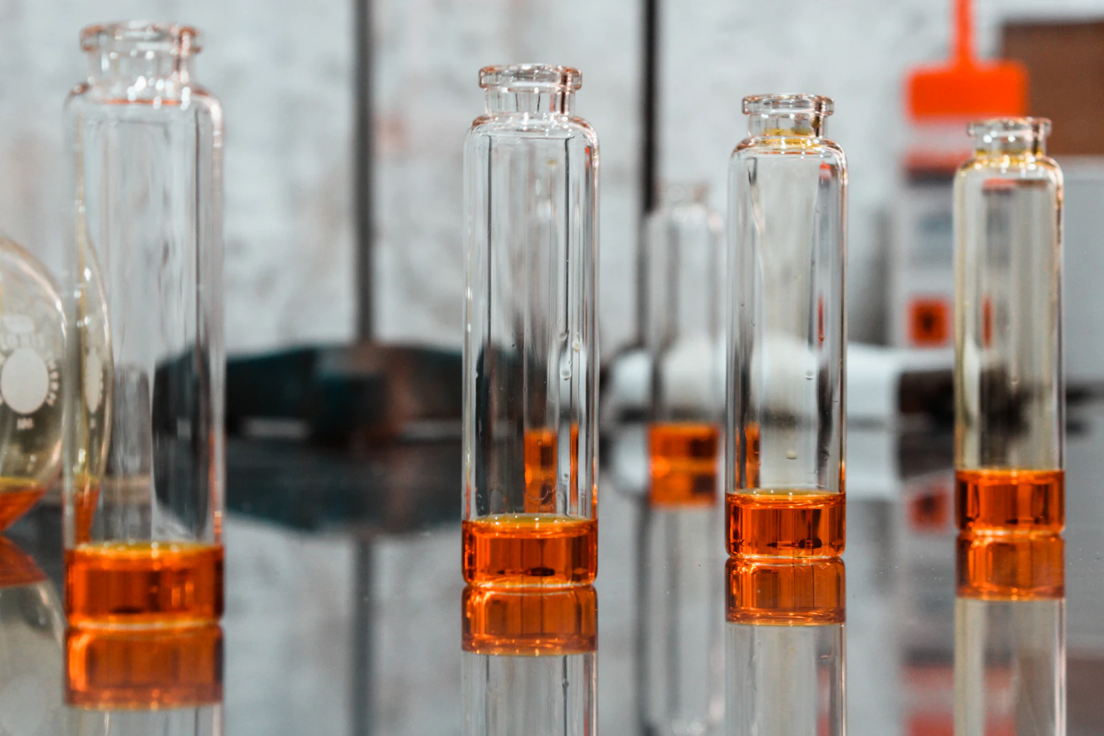 Laborgläser mit orangefarbener Flüssigkeit im Labor – 3. Semester Zahnmedizin